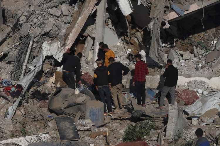 Warga Palestina memandangi puing-puing permukiman yang hancur di Rafah, selatan Jalur Gaza, setelah serangan udara Israel pada Senin, 4 Desember 2023.(SinPo.id/AFP)