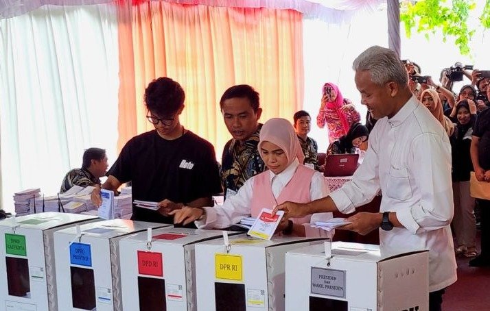 Capres Ganjar Pranowo memasukkan surat suara saat mencoblos di TPS 11 Kelurahan Lempongsari. (SinPo.id/Antara)