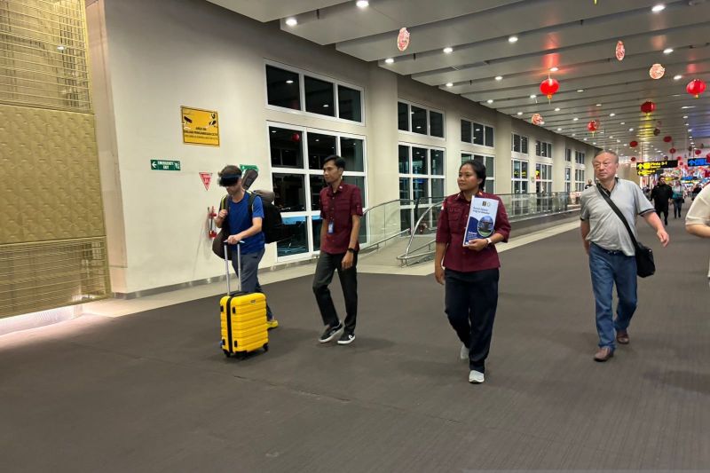 Petugas Imigrasi mendampingi WNA AS yang dideportasi karena melanggar izin tinggal di Bandara Internasional I Gusti Ngurah Rai, Bali. (SinPo.id/Dok. Kemenkumham Bali)