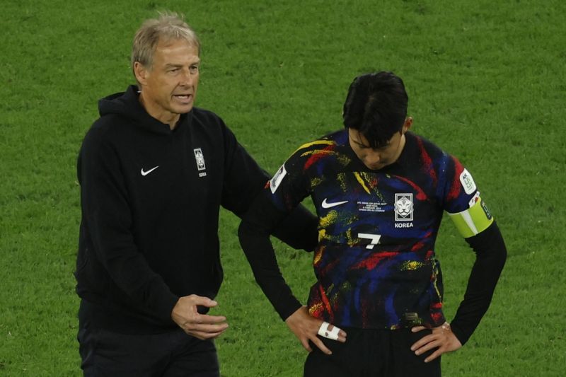 Pelatih Korea Selatan asal Jerman Jurgen Klinsmann berbicara dengan gelandang Son Heung-min setelah kalah dari Yordania. (SinPo.id/AFP)