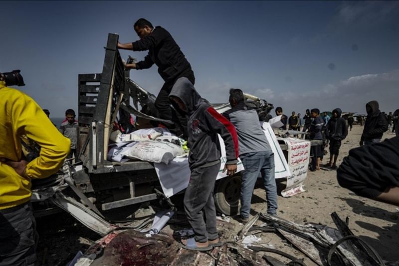 Warga Palestina mengeluarkan puing-puing kendaraan bantuan kemanusiaan yang rusak berat di Deir al-Balah, Gaza. (SinPo.id/Anadolu)